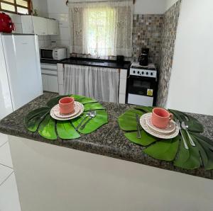 a kitchen with two plates and two cups on a counter at Casa Trancoso in Trancoso