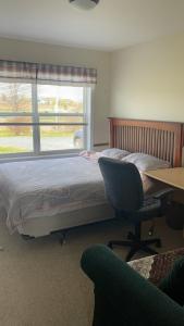 1 dormitorio con cama, escritorio y ventana en Lica’s house, en Vernon Bridge