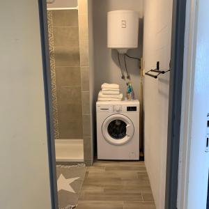 a laundry room with a washing machine and a washer at Marija Seršić “Narca” in Baška