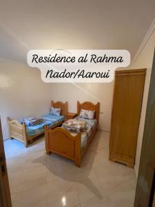 Residence al Rahma 05 في Monte ʼArrouit: غرفة بسريرين وعلامة تدل على المرونة في karma nadalami