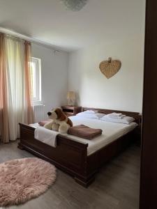 un osito de peluche sentado en una cama en un dormitorio en Seosko domacinstvo Lelic Ristivojevic, en Valjevo