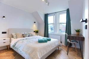 a bedroom with a bed and a desk and a window at Luxurious City Centre Apartment in Perth