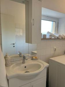 ein weißes Badezimmer mit einem Waschbecken und einem Spiegel in der Unterkunft Holiday house Misetic in Selca