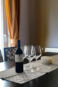 a bottle of wine sitting on a table with glasses at Apartman Luka in Zadar