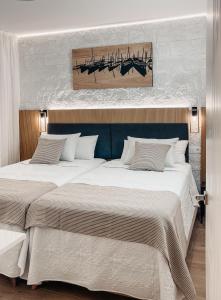 een slaapkamer met 2 bedden en een schilderij aan de muur bij Sapphire Riviera Residence in Adeje