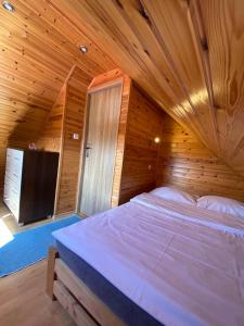 sypialnia z dużym łóżkiem w drewnianym pokoju w obiekcie Domki u Barta w Trzęsaczu