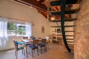 a dining room with a table and chairs and a spiral staircase at Cabaña para relajarse con vista panorámica in Villa General Belgrano +18 photos