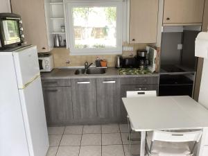 a small kitchen with a sink and a table at T2 calme proche plage de Porcé in Saint-Nazaire