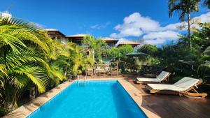 uma piscina com cadeiras e uma casa em Pousada Meu Talento em Alto Paraíso de Goiás