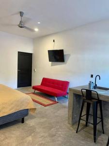 a room with a red couch and a red chair at océano estudio 2 in Sayulita