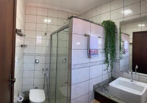a bathroom with a sink and a glass shower at Hospedaria Canto do Vinhedo in Espirito Santo Do Pinhal