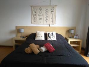 a bedroom with a bed with two stuffed animals on it at Alquiler Balcarce in Rosario