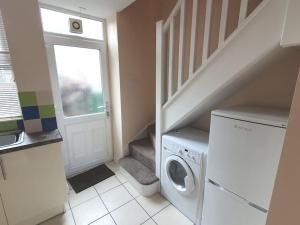 a laundry room with a washing machine and a staircase at Hill View Cottage in Bala