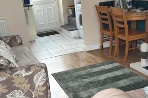 a living room with a couch and a table and a kitchen at Hill View Cottage in Bala +3 photos
