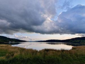 a large body of water under a cloudy sky at Hill View Cottage in Bala