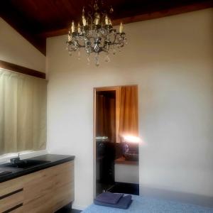 a bathroom with a chandelier and a sink at Villa Tilly in Trarivi