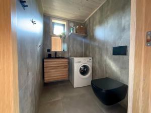 małą łazienkę z pralką i umywalką w obiekcie Atlantic Panorama Lofoten w mieście Leknes