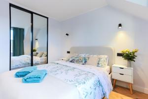 a bedroom with a white bed and a large mirror at Luxurious City Centre Apartment in Perth
