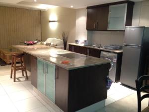a kitchen with a sink and a refrigerator at Umhlanga Gateway Apartments in Durban +2 photos