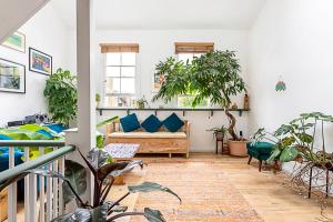 a living room with potted plants and a couch at Quirky Spacious House in the Heart of Hackney in London