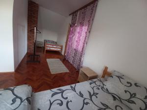 1 dormitorio con 1 cama, vestidor y cortinas en Vikendica Savić, en Šipovo