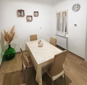 een eetkamer met een witte tafel en stoelen bij La Perla in Francavilla Fontana