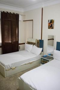 una habitación con dos camas y una ventana en cairo view hotel, en El Cairo