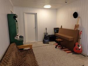 een woonkamer gevuld met gitaren en een piano bij Omakotitalo rauhallisella alueella in Rauma