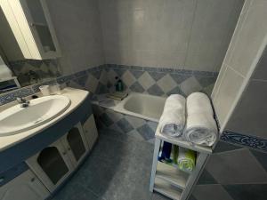 La salle de bains est pourvue d'un lavabo, d'une baignoire et de serviettes. dans l'établissement The Pearl with Private Beach Access, à Benalmádena