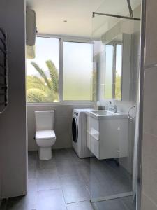 a bathroom with a toilet sink and a washing machine at Entre el verde y el azul in Fuengirola