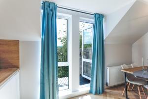 a room with a window with blue curtains and a table at Luxurious City Centre Apartment in Perth