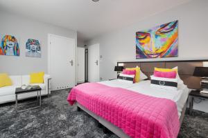 een slaapkamer met een groot bed en een roze deken bij Majestique in Pobierowo