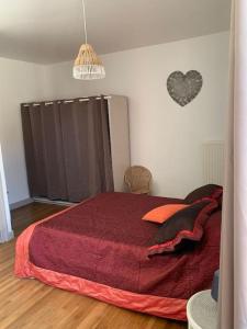 a bedroom with a red bed with a heart on the wall at La Vallée Claire in Le Blanc