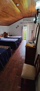 a room with three beds and a desk and a table at Alojamento Local Céu-Azul in Porto de Mós