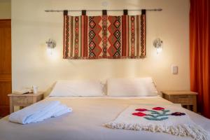 1 dormitorio con 1 cama con 2 toallas en Cabaña para relajarse con vista panorámica en Villa General Belgrano