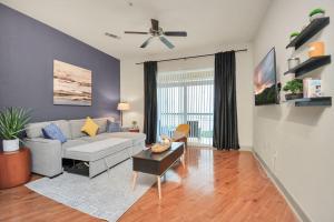 a living room with a couch and a ceiling fan at Lux Mid-Rise Walking Distance to NRG Stadium in Houston
