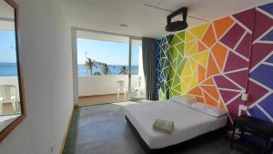 a bedroom with a bed and a colorful wall at Panamerican Hostel in Santa Marta