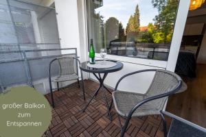 uma mesa e cadeiras numa varanda com uma garrafa de vinho em Businessapartment I Balkon I Messe I Parken I schnelles WLAN em Essen