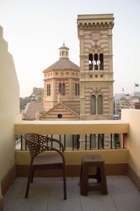 um banco numa varanda com um edifício em cairo view hotel em Cairo