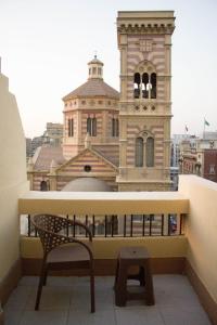 um banco numa varanda com um edifício em cairo view hotel em Cairo