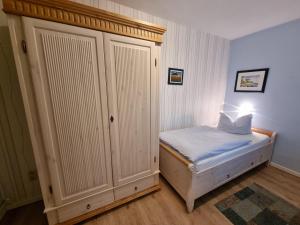 - une petite chambre avec un lit et un placard dans l'établissement Ferienwohnung-Wiesenblick-mit-GRATIS-Leistungen, à Thesenvitz