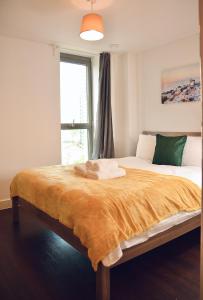 a bedroom with a large bed with a large window at Venice Court London 2Bedroom Apartment in London