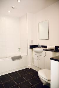 a bathroom with a toilet and a sink and a tub at Venice Court London 2Bedroom Apartment in London