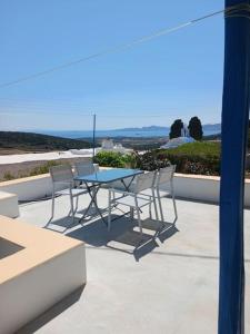 una mesa y sillas en la parte superior de un patio en The Kamari Blue Dome house, en Kampos