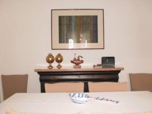 ein Esszimmer mit einem Tisch und einem Bild an der Wand in der Unterkunft The Kamari Blue Dome house in Kampos Paros