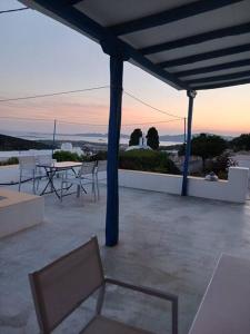 a patio with a table and chairs on a roof at The Kamari Blue Dome house in Kampos Paros