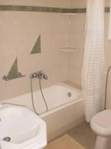 a bathroom with a tub and a toilet and a shower at The Kamari Blue Dome house in Kampos Paros