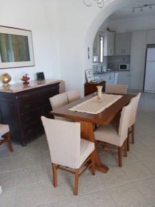 a dining room table with chairs and a kitchen at The Kamari Blue Dome house in Kampos Paros