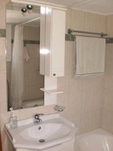 y baño con lavabo blanco y espejo. en The Kamari Blue Dome house, en Kampos