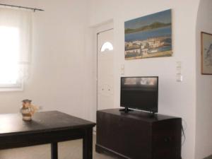 a living room with a flat screen tv on a table at The Kamari Blue Dome house in Kampos Paros